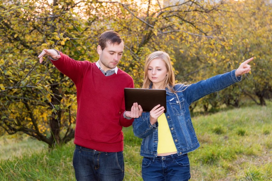 man and woman pointing in opposite directions