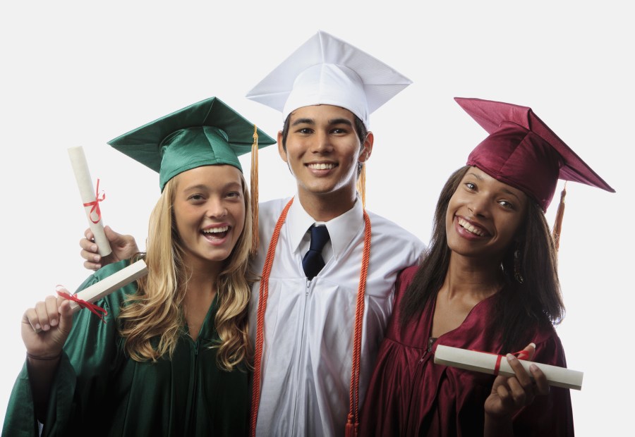 three graduates in cap and gown with diplomas